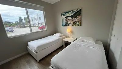 two beds in a small room with a window at Family Comfort Near Top Spots-Relaxing Stay for Everyone in Golden Glades