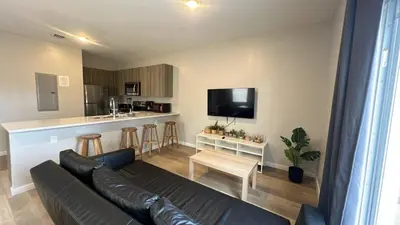 a living room with a couch and a kitchen at Family Comfort Near Top Spots-Relaxing Stay for Everyone in Golden Glades