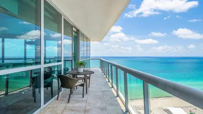 a balcony with a table and chairs and the ocean at The Setai Miami Private Luxury Residences in Miami Beach