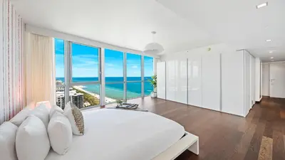 a bedroom with a large white bed and large windows at The Setai Miami Private Luxury Residences in Miami Beach
