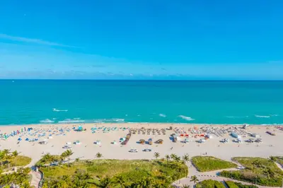 a beach with a lot of umbrellas and the ocean at The Setai Miami Private Luxury Residences in Miami Beach
