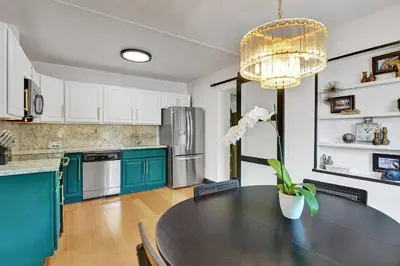a kitchen with a black table and green cabinets at Heated Saltwater Pool Family & Pet-Friendly Oasis in Fort Lauderdale