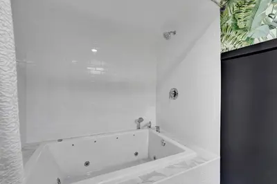 a white bath tub in a white bathroom at Heated Saltwater Pool Family & Pet-Friendly Oasis in Fort Lauderdale