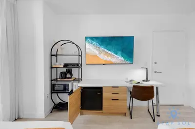 a white desk in a room with a table at Stylish -2BR Apartment -Balcony & Pool in Hallandale Beach