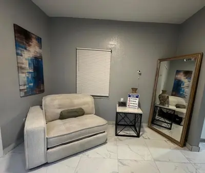 a living room with a chair and a mirror at Belle Vista in Miami