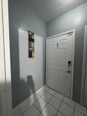 a hallway with a white door and a tile floor at Belle Vista in Miami