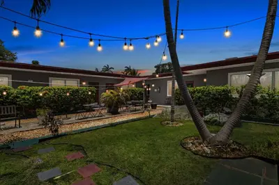 a backyard with a palm tree and lights at 1BR Studio Parking, BBQ, Garden In Hollywood in Hollywood