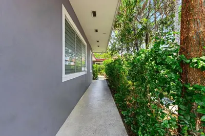 a walkway next to a building with a tree at Bright 2BR Getaway | BBQ, Garden & Parking in Hollywood