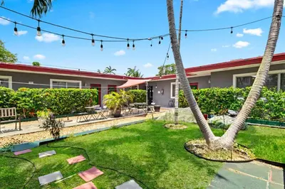 a yard with palm trees in front of a house at Relaxing 1BR w/ BBQ, Patio & Convenient Access in Hollywood