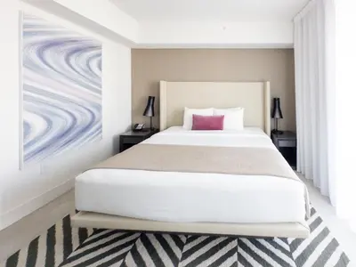 a bedroom with a large white bed with a purple pillow at 3 BDR Beach Bliss in Hollywood