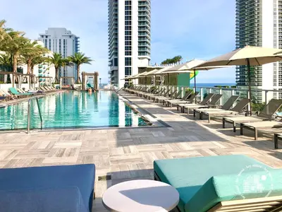 a swimming pool with chairs and umbrellas on a building at 3 BDR Beach Bliss in Hollywood