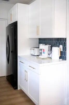 a kitchen with white cabinets and a black refrigerator at Miami Freedom Park Oasis by H&S in Miami