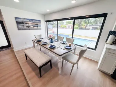 a dining room with a table and chairs and a large window at Miami Freedom Park Oasis by H&S in Miami