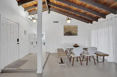 a dining room with white walls and a table and chairs at Central Stunning Villa with Heated Pool Cabana in Hollywood Ridge Farms