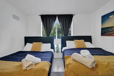 two beds sitting next to each other in a bedroom at Central Stunning Villa with Heated Pool Cabana in Hollywood Ridge Farms