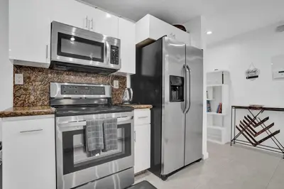 a kitchen with a stainless steel refrigerator and a microwave at Central Stunning Villa with Heated Pool Cabana in Hollywood Ridge Farms