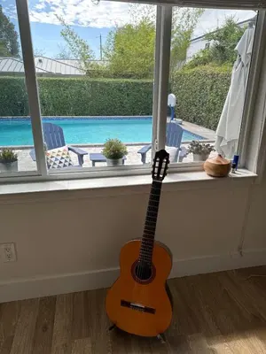 a guitar sitting in a window next to a pool at Charming two Bedroom in the Gables For Rent in Miami