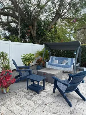 a patio with two chairs and a table and a bed at Charming two Bedroom in the Gables For Rent in Miami