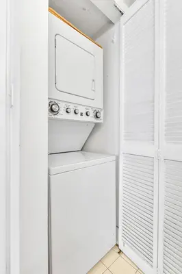 a white kitchen with a microwave above a refrigerator at Luxury3 Miami Brickell Stay-Bay View in Miami