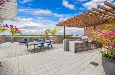 a patio with a table and chairs under a pergola at Midblock Midtown Miami 1B W Spa Pool Gym in Miami