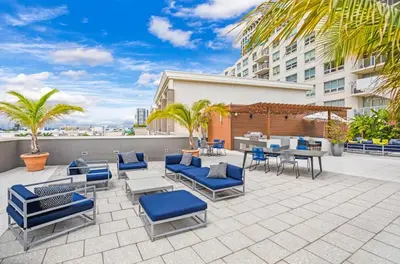 a patio with blue chairs and tables and a building at Midblock Midtown Miami 1B W Spa Pool Gym in Miami