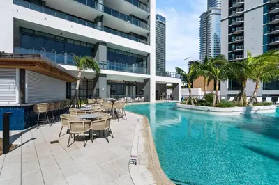 a swimming pool with tables and chairs next to a building at Downtown Miami 2BR-2BA Panoramic City Views in Miami