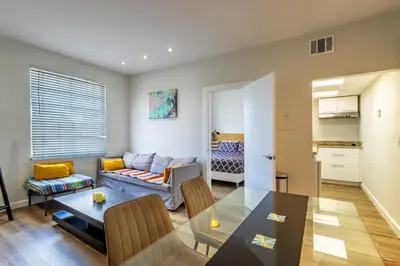 a living room with a table and a couch at Coastal 2BR Escape | Walk to Beach & 2 Queen Beds in Miami Beach