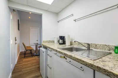 a kitchen with a sink and a counter top at Coastal 2BR Escape | Walk to Beach & 2 Queen Beds in Miami Beach
