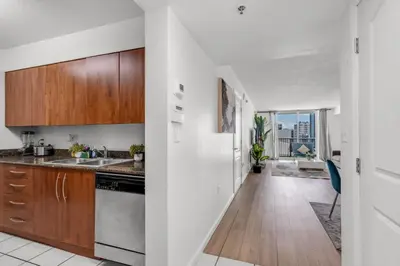an open kitchen with wooden cabinets and a counter top at Enjoy Brickell Living 2 BR Retreat With Free Parking in Miami