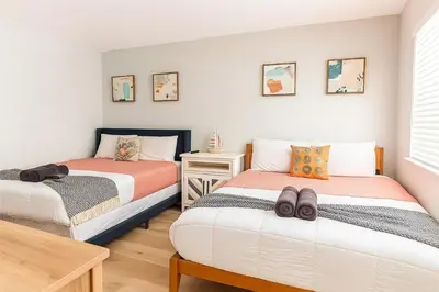 a bedroom with two beds and a table at Dania Beach 1BR | Steps to Ocean + Parking in Dania Beach
