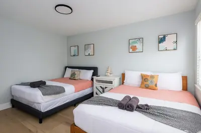 a bedroom with two beds and a desk at Dania Beach 1BR | Steps to Ocean + Parking in Dania Beach