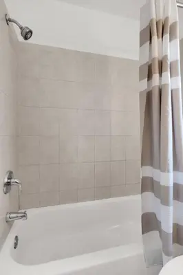 a bathroom with a tub and a shower curtain at Triplex with 3 Bedrooms, 6 Min/Beach+Free Parking in Dania Beach