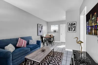 a living room with a blue couch and a table at Cozy 1BR Retreat | 6-Min to Beach + Free Parking in Dania Beach