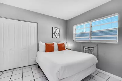 a white bedroom with a large bed and a window at Cozy 1BR Retreat | 6-Min to Beach + Free Parking in Dania Beach