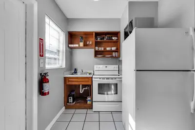 a kitchen with a white refrigerator and a stove at Cozy 1BR Retreat | 6-Min to Beach + Free Parking in Dania Beach