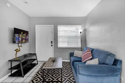 a living room with a blue couch and a table at Cozy 1BR Retreat | 6-Min to Beach + Free Parking in Dania Beach