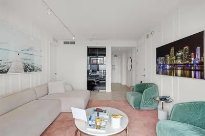 a living room with a white couch and green chairs at W South Beach 1B Residence Ocean View in Miami Beach