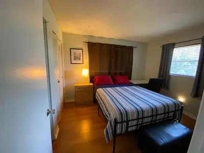 a small bedroom with a bed with red pillows at Econoroom Hollywood in Hollywood
