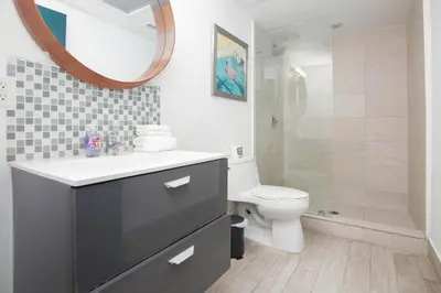 a bathroom with a sink and a toilet and a mirror at Boutique Apartments SoBe in Miami Beach