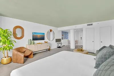 a bedroom with a large bed and a living room at Brand New Mondrian - Miami Beach Waterfront Condo in Miami Beach
