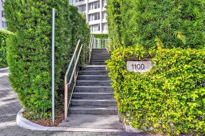 a stairway in a hedge with a sign on it at Brand New Mondrian - Miami Beach Waterfront Condo in Miami Beach