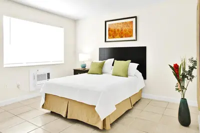 a bedroom with a large white bed with green pillows at Mimo 10 - Kitchen - Walkable - Fast WiFi - Free Parking in Miami