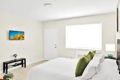 a white bedroom with a bed and a window at Mimo 10 - Kitchen - Walkable - Fast WiFi - Free Parking in Miami