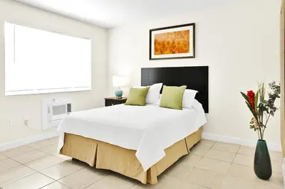 a white bedroom with a large bed with green pillows at New Mimo 8 New -Walkable - Smart TV - Nespresso - Free Parking in Miami