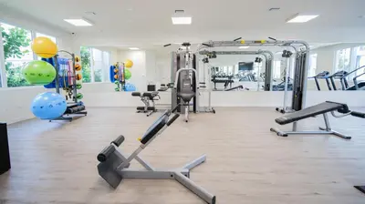 a gym with several tread machines and a mirror at Beachside Bliss, 1BR Condo with Pool at Dania Beach in Dania Beach