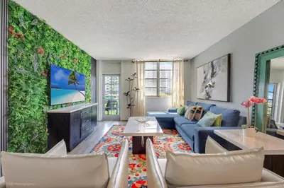 a living room with a blue couch and a green wall at Beachfront Oasis in Sunny Isles 4BR, Pool & Tennis in Sunny Isles Beach