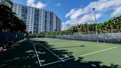 a tennis court in front of a large building at Beachfront Oasis in Sunny Isles 4BR, Pool & Tennis in Sunny Isles Beach