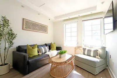 a living room with a black leather couch and a table at South Beach South of Fifth 1 Bedroom Apartment Steps to Beach Sleeps 5 Pet Friendly in Miami Beach