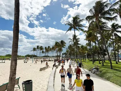 a group of people walking on the beach at South Beach South of Fifth 1 Bedroom Apartment Steps to Beach Sleeps 5 Pet Friendly in Miami Beach