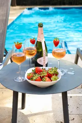 a table with a plate of salad and a bottle of wine and glasses at Villa Miami Lakes in Hialeah